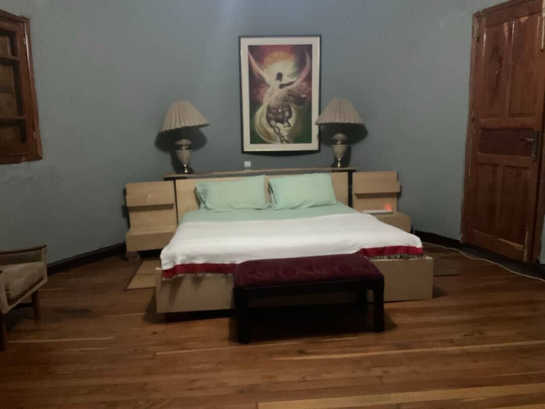 Comfortable bedroom with blue walls and traditional artwork